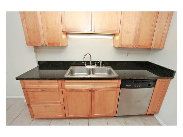 1800 Lavaca Street, Unit 204 Austin, TX 78701 - Photo 8 of 12 a kitchen with granite countertop a sink a stove and cabinets