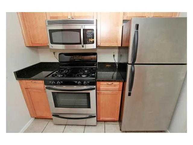 a kitchen with stainless steel appliances granite countertop a refrigerator stove and microwave