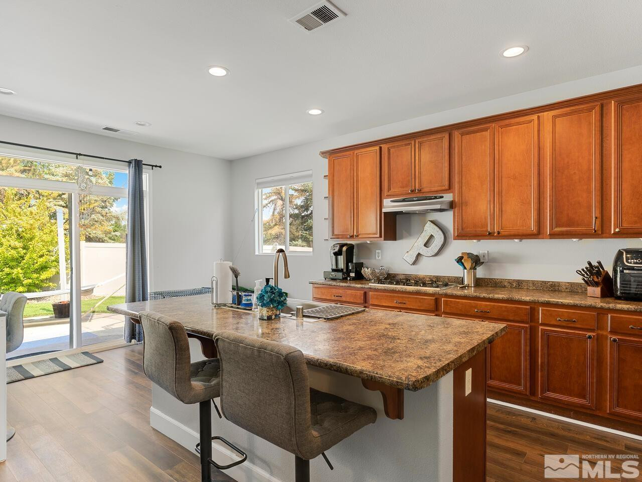 10805 Dancing Aspen Drive Reno, NV 89521 - Photo 12 of 25 a kitchen with stainless steel appliances granite countertop sink stove top oven and cabinets