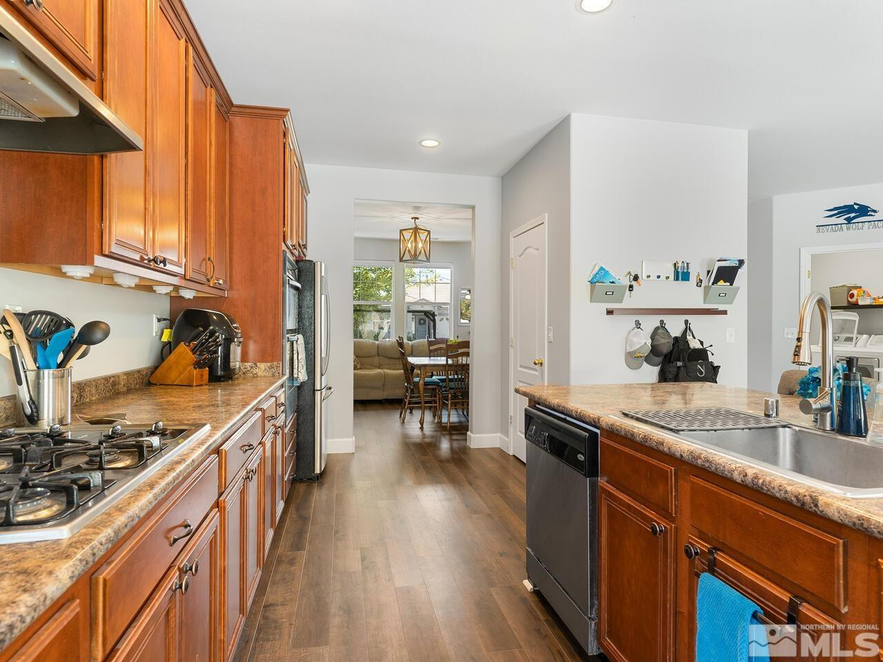 10805 Dancing Aspen Drive Reno, NV 89521 - Photo 15 of 25 a kitchen with stainless steel appliances granite countertop sink stove top oven and cabinets