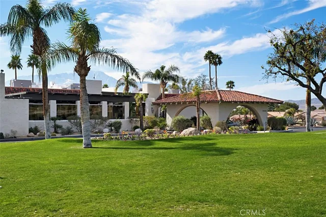 a view of a house with a yard and sitting area