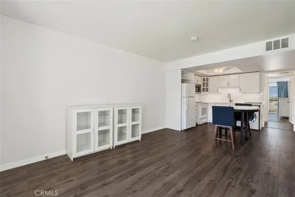 a view of a kitchen with furniture and wooden floor