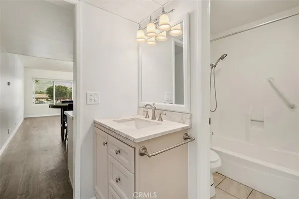 a bathroom with a granite countertop sink a mirror and a bathtub