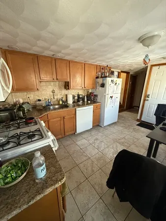 a kitchen with furniture a refrigerator and a stove