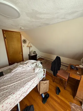a bedroom with a bed and wooden floor