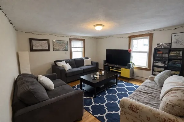 a living room with furniture a flat screen tv and a window