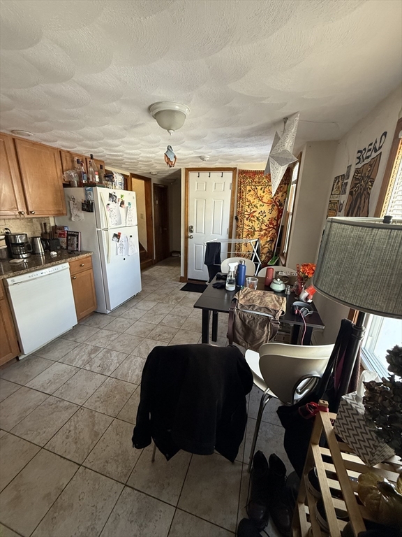 585 Somerville, Unit A1 Somerville, MA 02143 - Photo 3 of 19 a living room with furniture a flat screen tv and a floor to ceiling window
