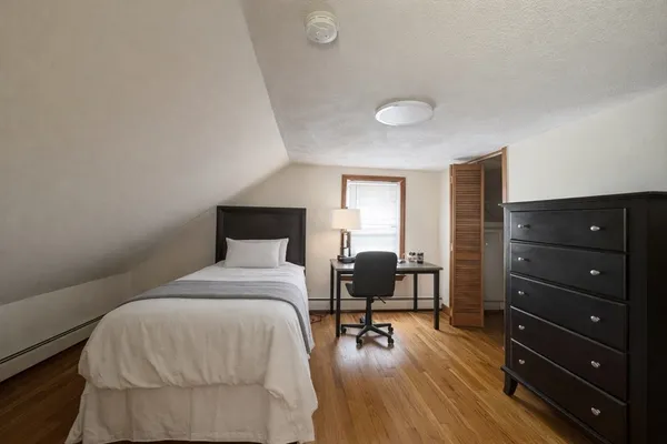 a bedroom with a bed mirror and a desk