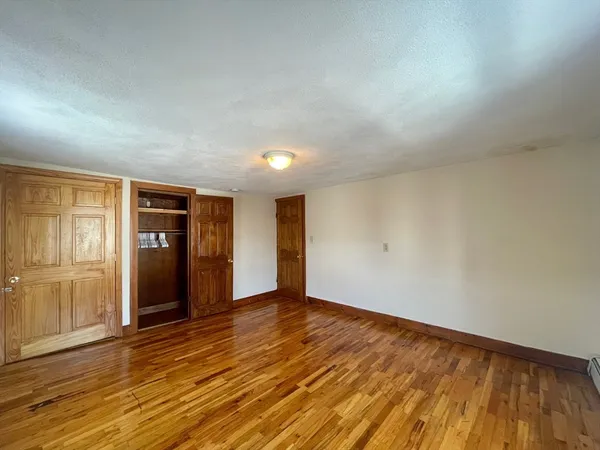 an empty room with wooden floor and closet