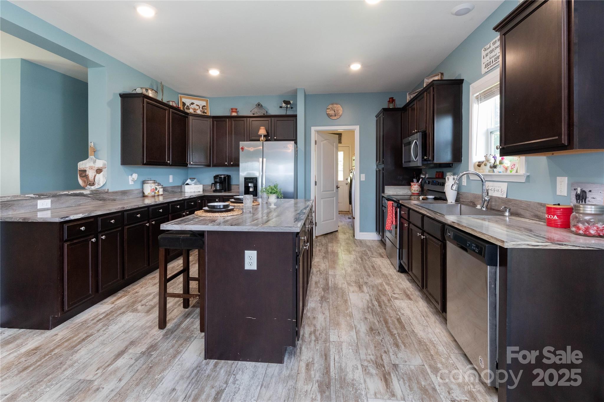 653 Mag Sluder Road Alexander, NC 28701 - Photo 12 of 28 a kitchen with a sink stove cabinets and wooden floor