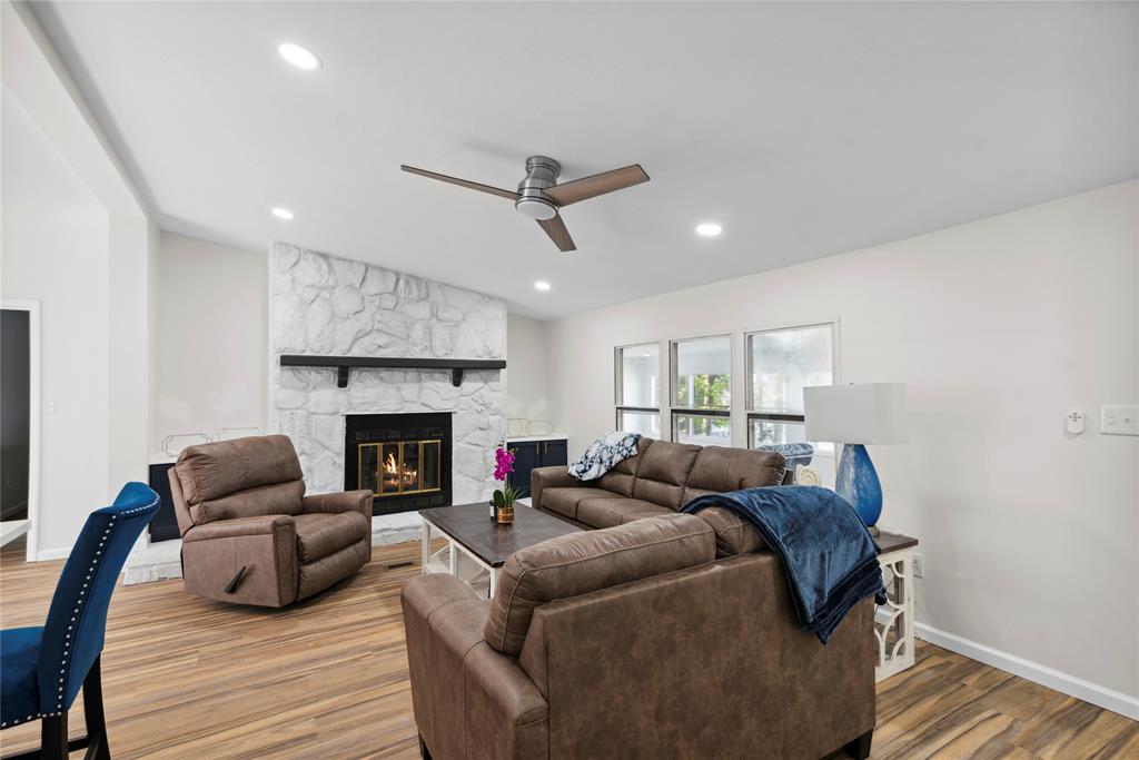 141 Mallard Road Ringgold, LA 71068 - Photo 12 of 33 Living area featuring a stone fireplace with a dark wood mantle, wood-finish flooring, recessed lighting, and a vaulted ceiling with a modern ceiling fan