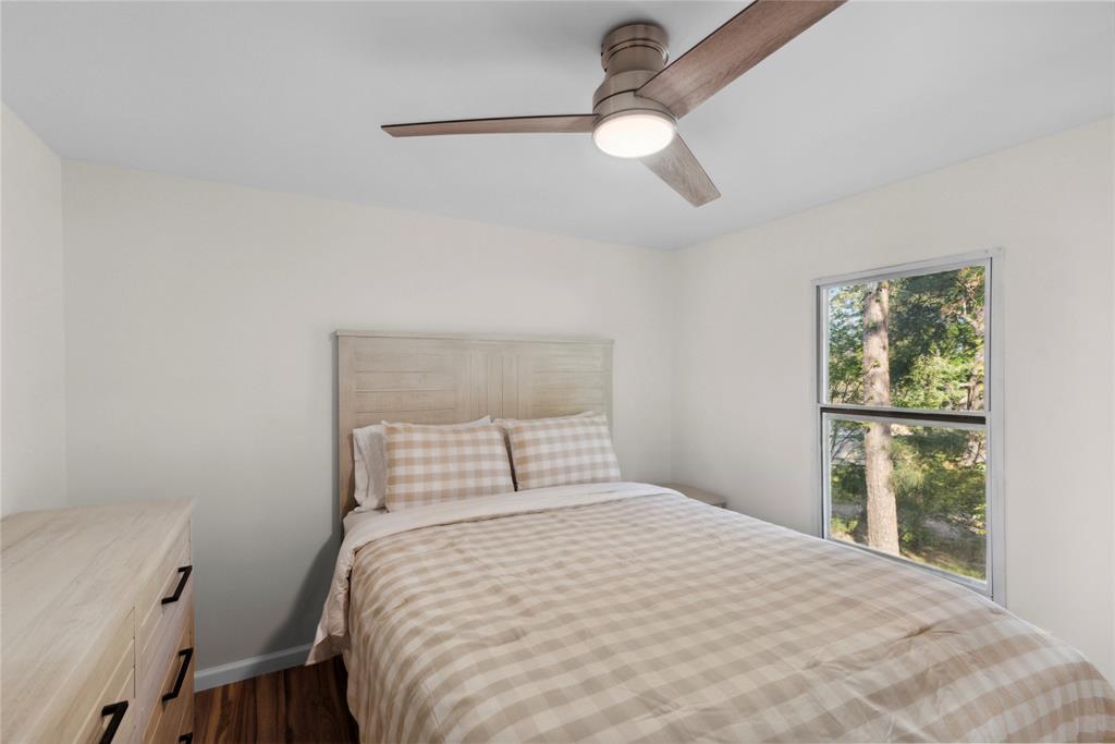 141 Mallard Road Ringgold, LA 71068 - Photo 25 of 33 Bright room featuring a ceiling fan with integrated lighting, wood-finish flooring, and a window with exterior tree views