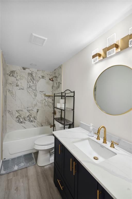 141 Mallard Road Ringgold, LA 71068 - Photo 4 of 33 Modern bathroom featuring a dark vanity with gold-tone hardware, a white countertop with an integrated sink, a circular mirror with a gold-tone frame, and a wall-mounted light fixture with gold-tone accents