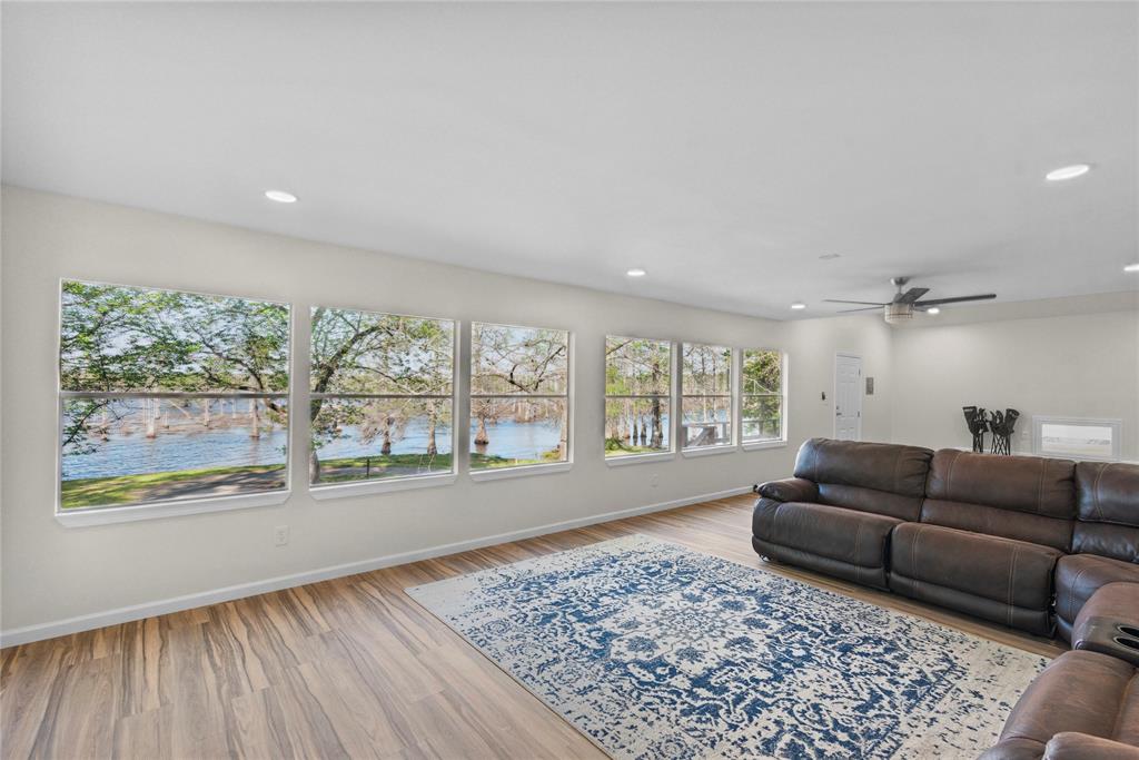 141 Mallard Road Ringgold, LA 71068 - Photo 6 of 33 Spacious living area featuring expansive windows overlooking a body of water, wood-finish flooring, a ceiling fan, and recessed lighting