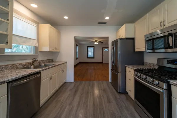 a kitchen with stainless steel appliances granite countertop a stove a sink and a refrigerator
