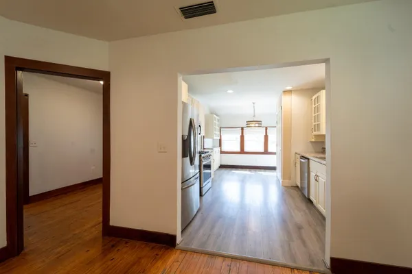 an empty room with wooden floor and a bathroom