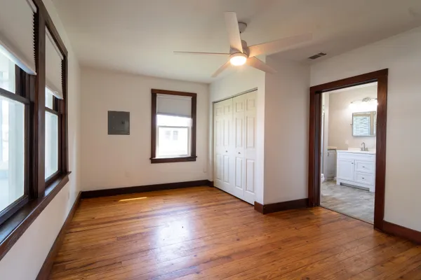 a view of an empty room with glass door and wooden floor