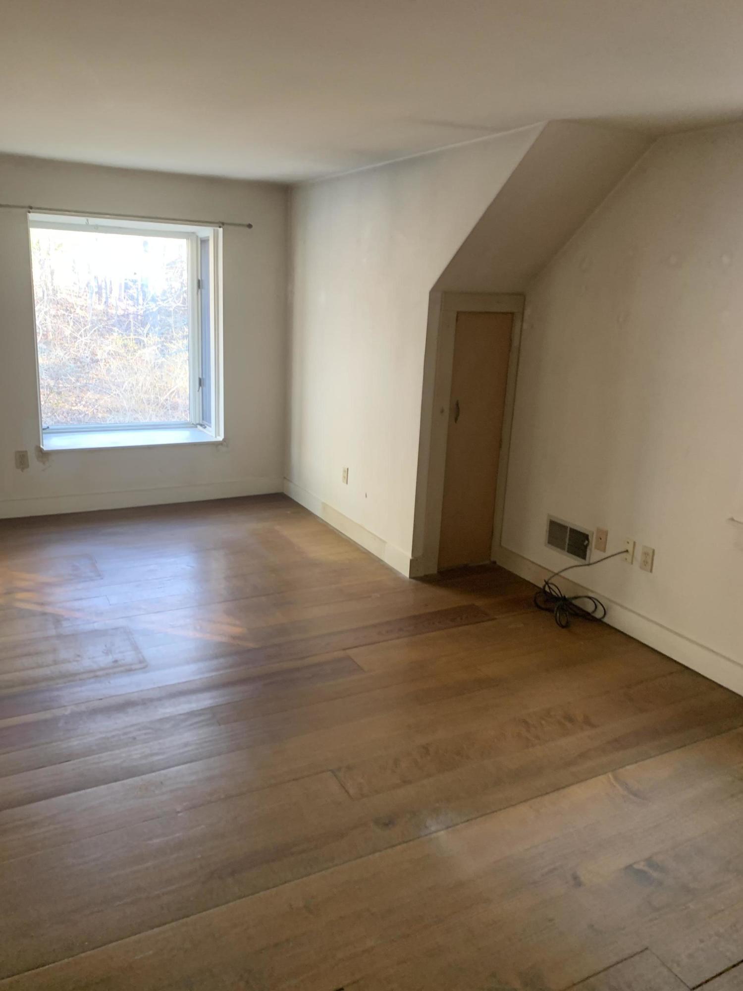 150 Browns Neck Road Wellfleet, MA 02667 - Photo 24 of 30 an empty room with wooden floor and windows