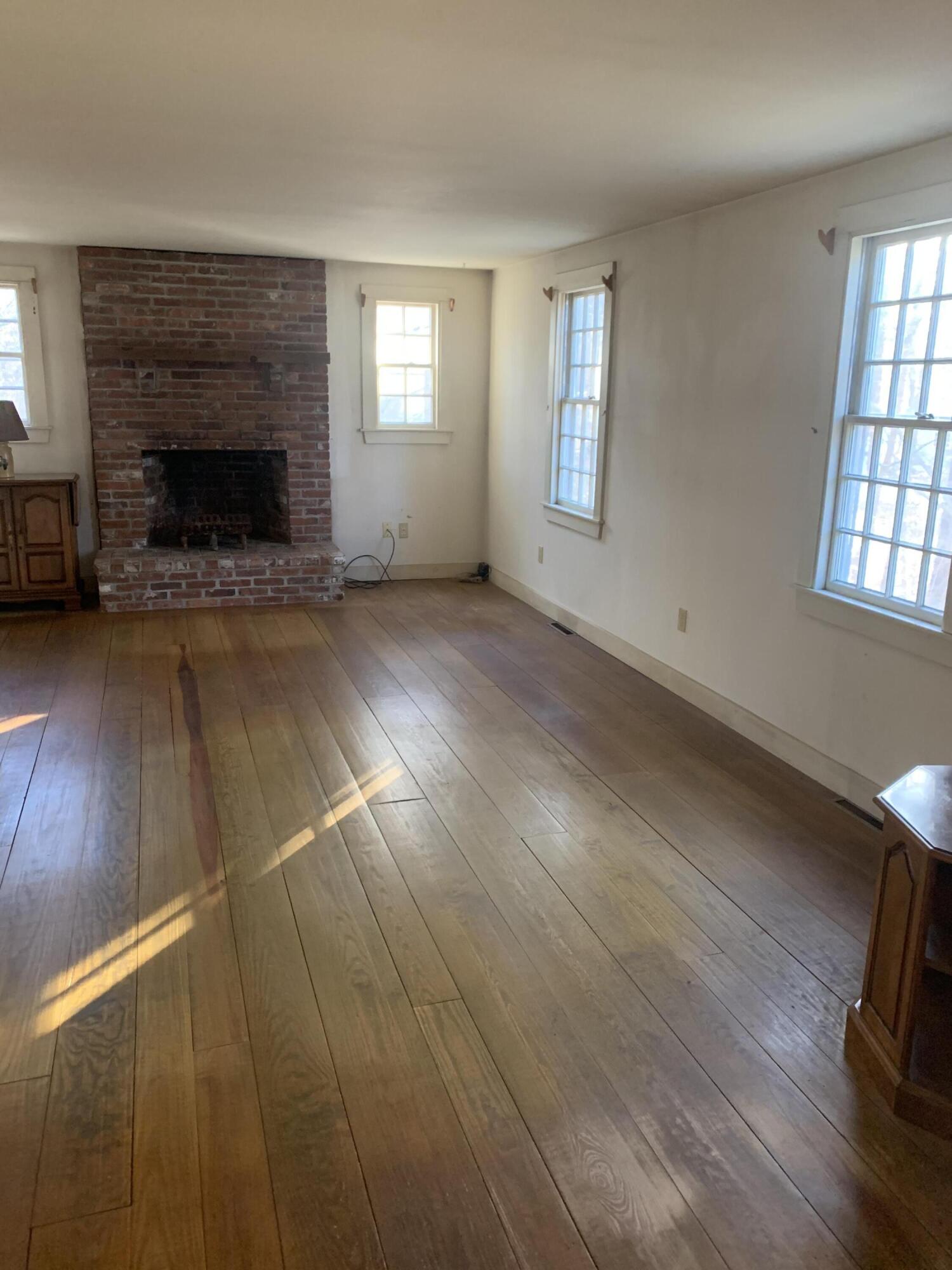 150 Browns Neck Road Wellfleet, MA 02667 - Photo 8 of 30 an empty room with windows and fireplace