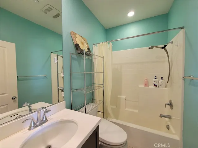 a kitchen with stainless steel appliances a dining table chairs refrigerator and sink