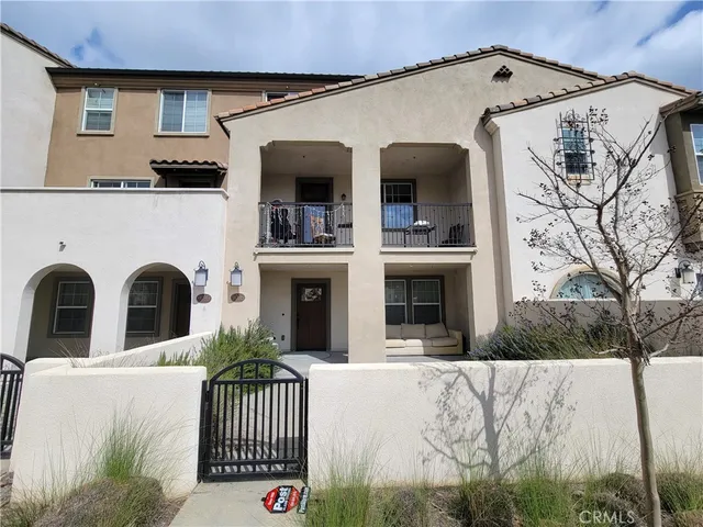 a view of a white house with large windows and a small yard