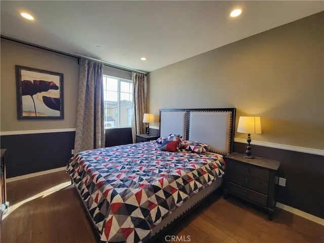 a bedroom with a bed and dresser with mirror