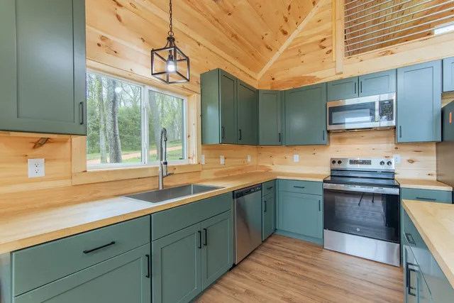 a kitchen with stainless steel appliances granite countertop a stove and a wooden floors