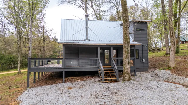 a backyard of a house with wooden fence and large trees