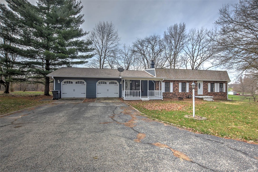 a view of a house with a yard and large tree