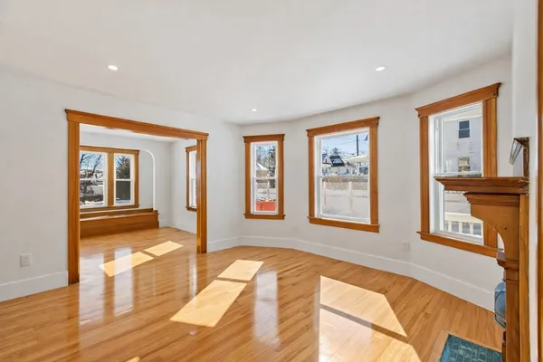 a spacious bedroom with wooden floor and large window