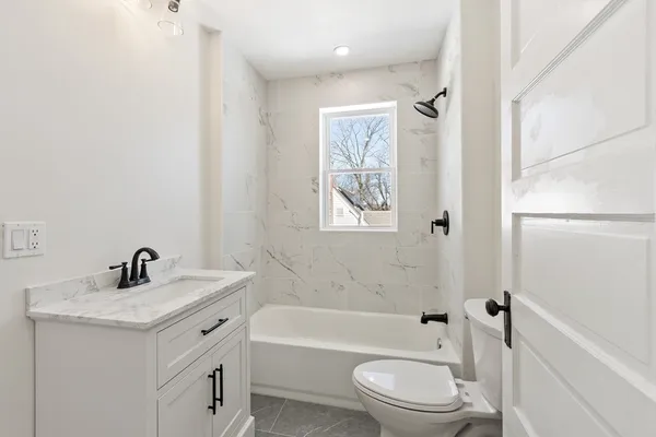 a bathroom with a sink a toilet and shower
