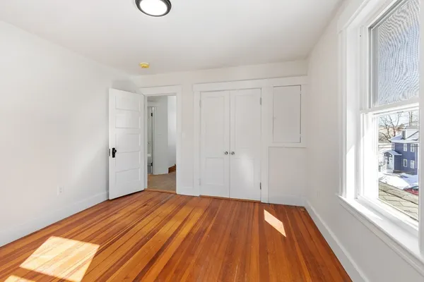 a view of a room with wooden floor and white walls