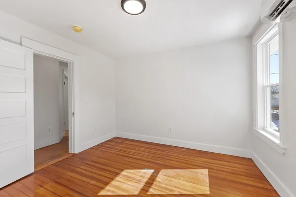 a view of a room with wooden floor and cabinet