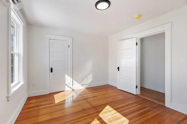 a view of empty room with wooden floor