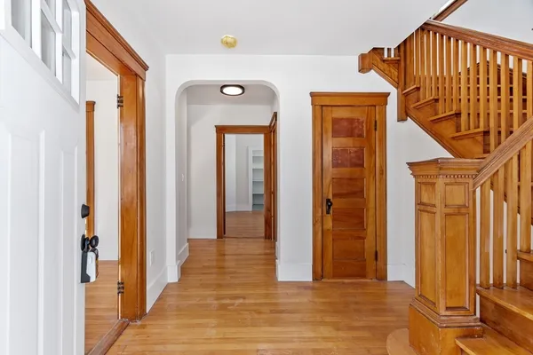 a view of a hallway with wooden floor and staircase