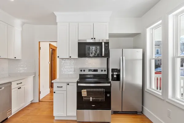 a kitchen with a refrigerator stove and wooden cabinets
