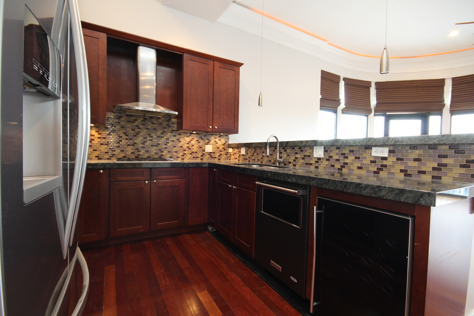 2954 West Irving Park Road, Unit 4C Chicago, IL 60618 - Photo 16 of 44 a kitchen with stainless steel appliances kitchen island granite countertop wooden cabinets and a stove