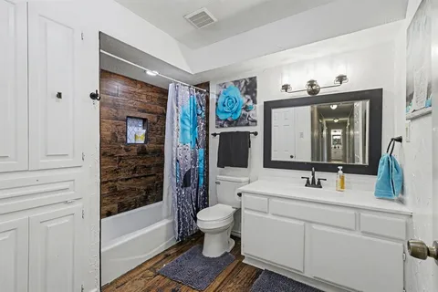 a bathroom with a sink a toilet and shower