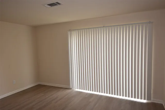 a view of a empty room with wooden floor