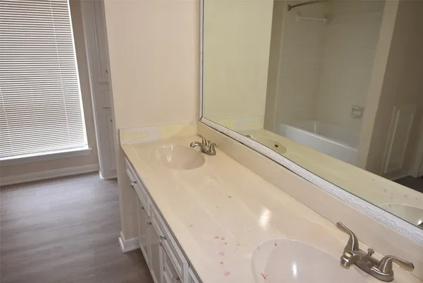 a bathroom with a tub sink and mirror