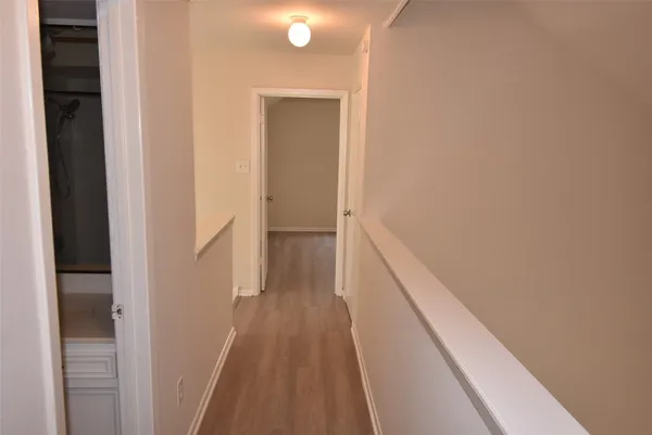 a view of hallway with wooden floor