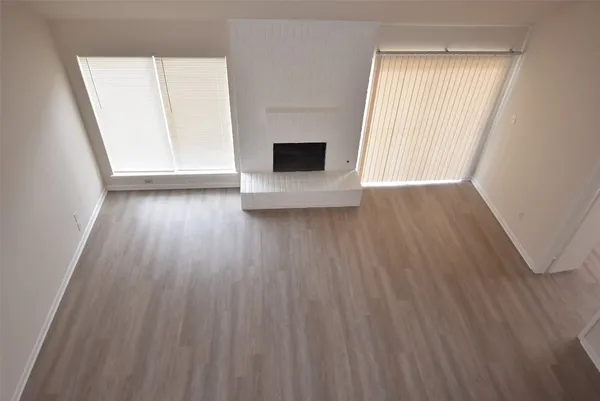 a view of a livingroom with wooden floor and a large window