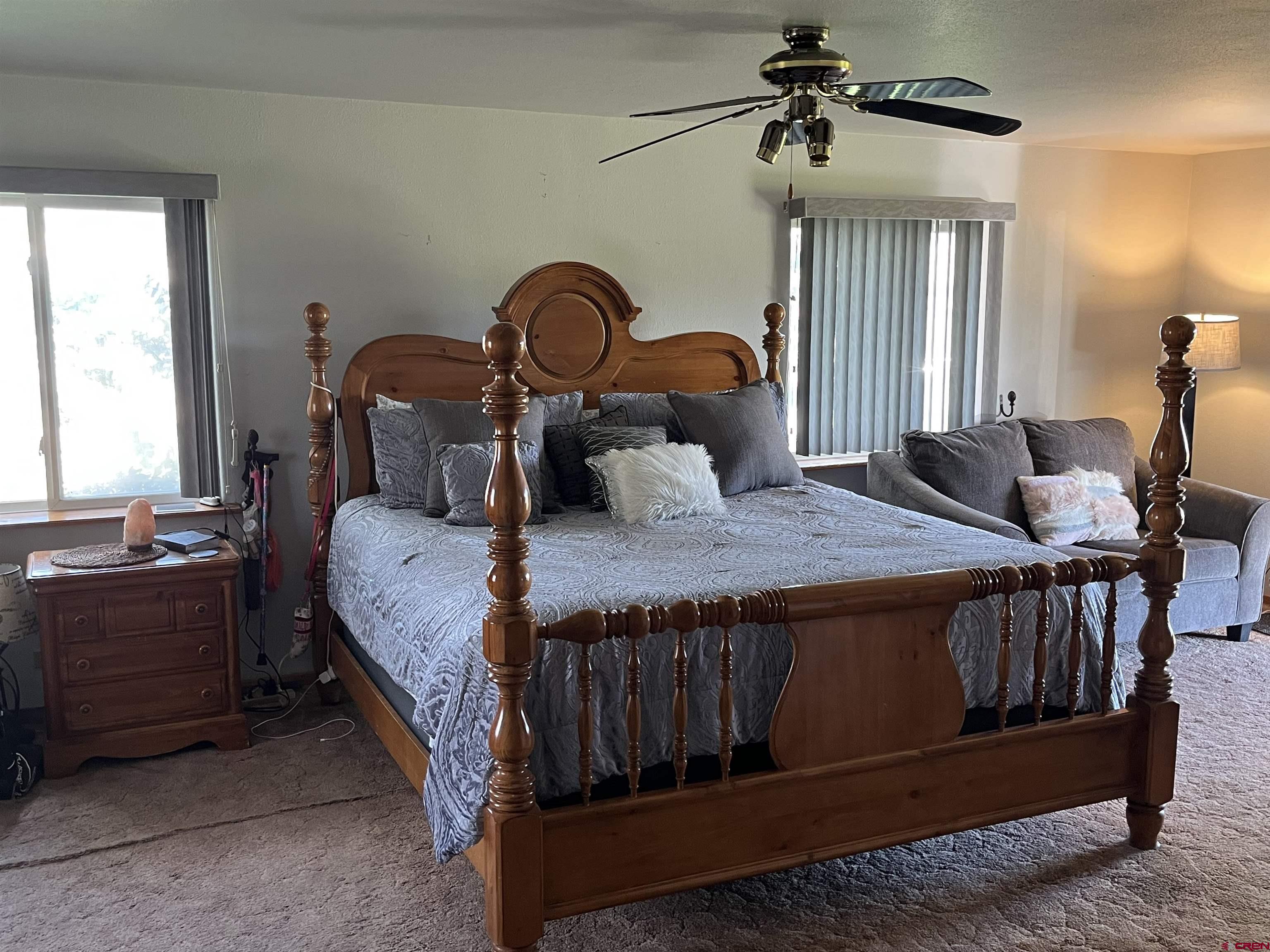 16400 6630 Road Montrose, CO 81401 - Photo 14 of 27 a bedroom with a bed a chandelier and dresser