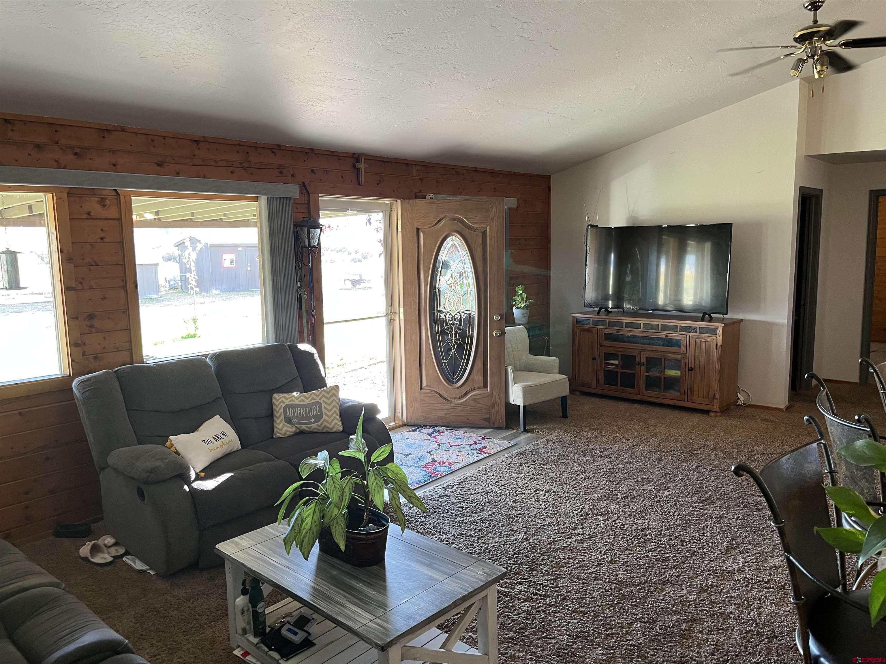 16400 6630 Road Montrose, CO 81401 - Photo 8 of 27 a living room with furniture and a flat screen tv