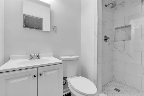 a bathroom with a sink a toilet and shower