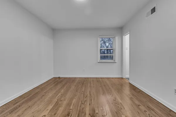 a view of a room with wooden floor and window