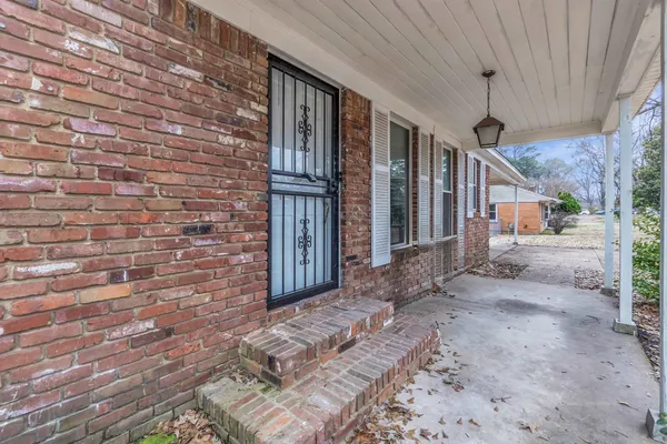 a view of a backyard with brick wall and wooden fence