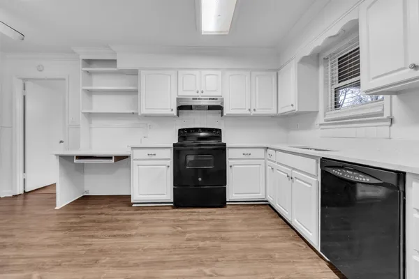 a kitchen with stainless steel appliances granite countertop a stove and white cabinets
