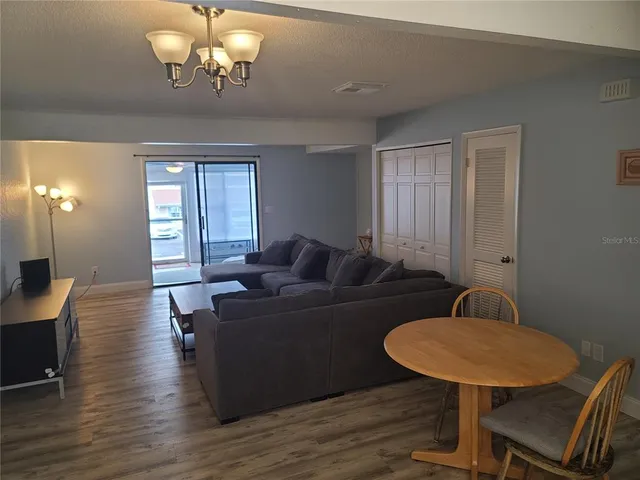 a living room with furniture a dining table and a chandelier