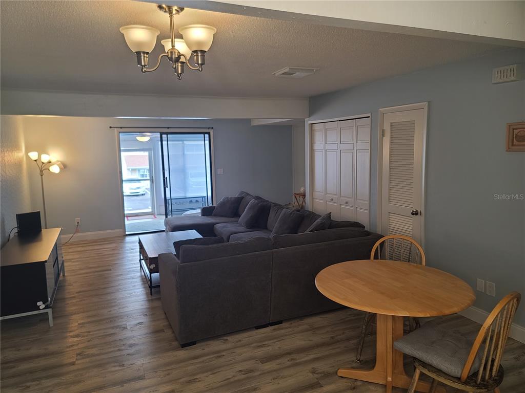 11001 Southeast Sunset Harbor Road, Unit C27 Summerfield, FL 34491 - Photo 12 of 53 a living room with furniture a dining table and a chandelier